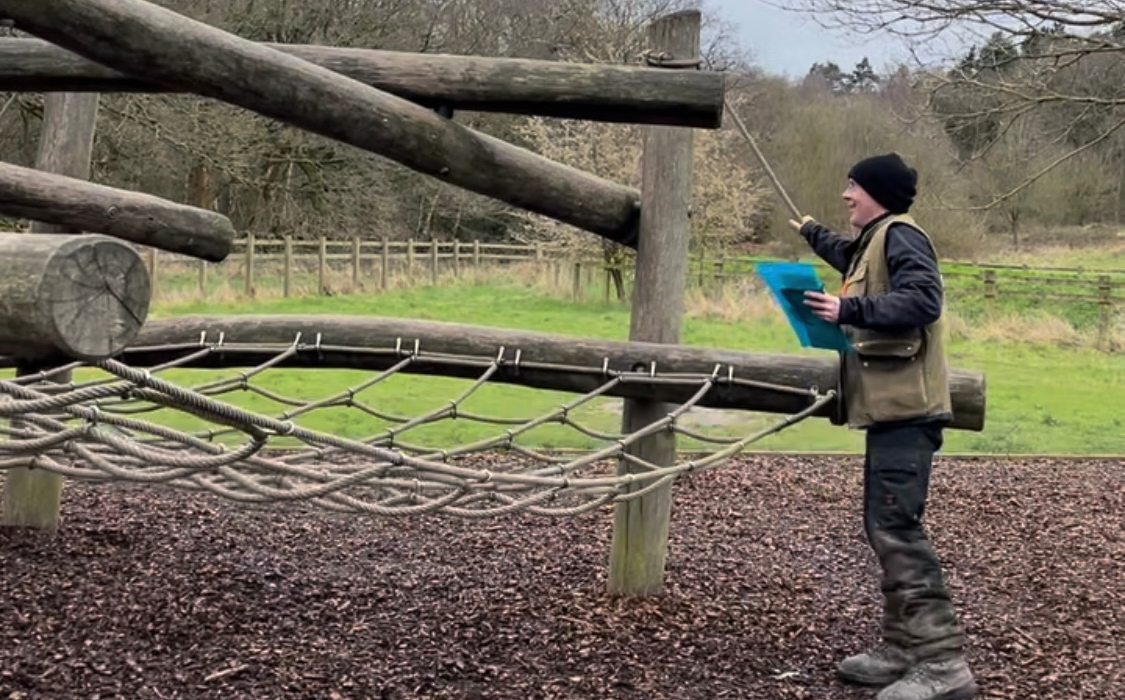 A ranger checks the play area to make sure equipment is safe